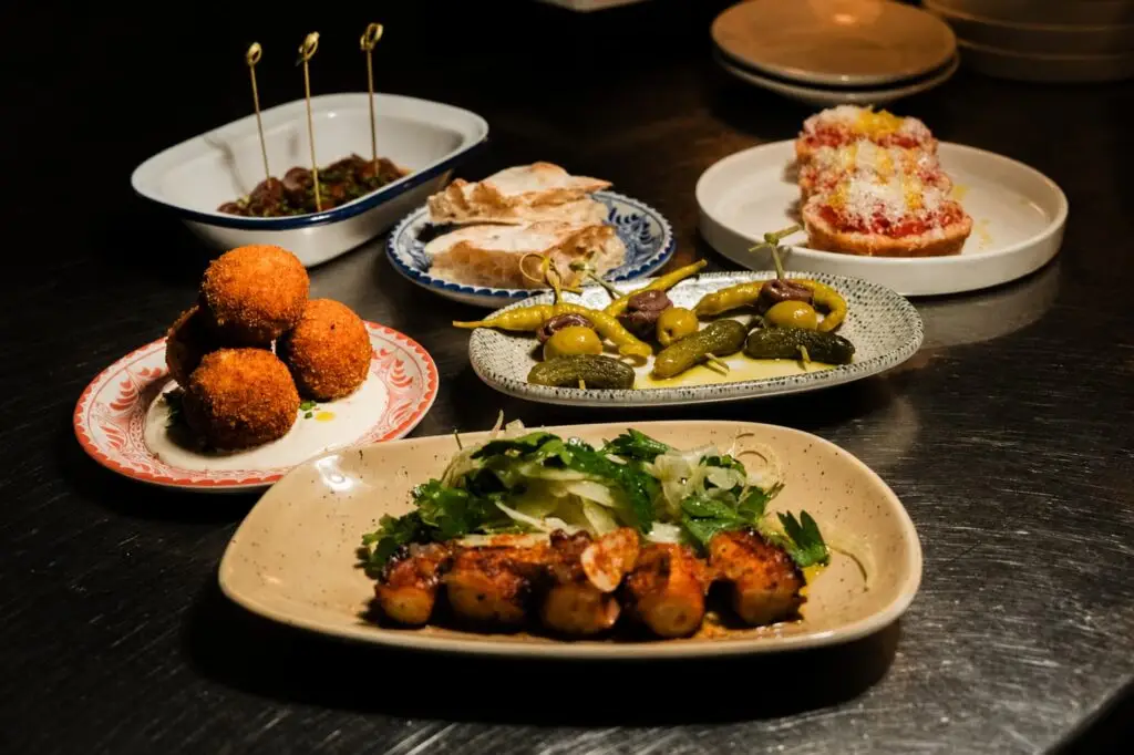 Shared plates of Basque pintxos — grilled skewers, marinated olives and crusty bread